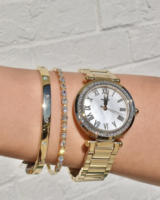 Yellow gold bangle bracelet, tennis bracelet, and Aaron-Taylor Swiss watch